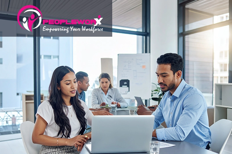 A small business leadership meeting with a collaborative tone, people reviewing reports or discussing people operations