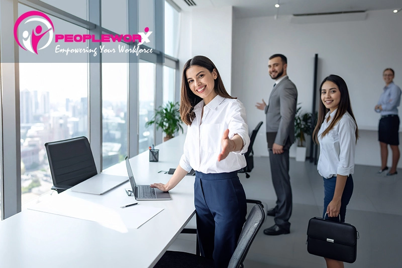 Manager welcoming a new employee while using digital onboarding tools in a small business office
