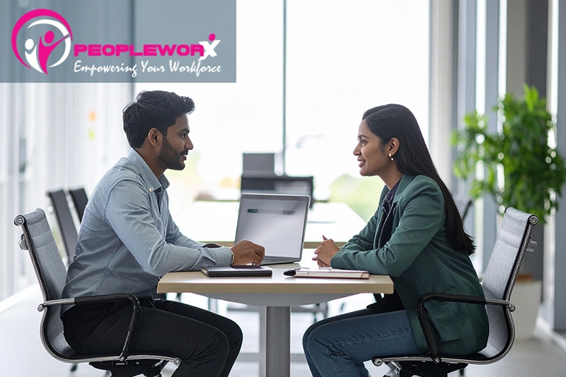 A manager having a constructive one-on-one conversation with an employee in a professional but relaxed environment
