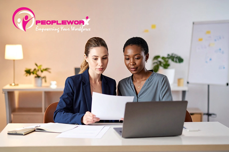 Manager and employee reviewing a performance review form during a workplace feedback conversation